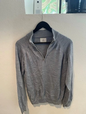 Grå halvzip-tröja från Bläck - Säljer en ljusblå stickad tröja från Bläck med halvdragkedja. Stilren modell som passar både till vardags och lite mer uppklätt. Tunn och skön kvalitet som funkar perfekt över en skjorta eller t-shirt. Använd men fortfarande i fint skick. Storlek: L Märke: Bläck Färg: Ljusblå Skriv gärna om du har frågor!
