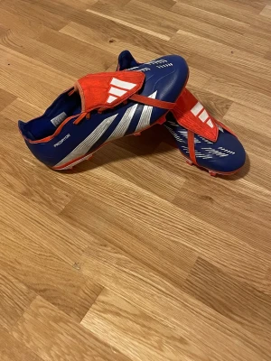 Adidas Predator Fotbollskor - Adidas Predator FG/AG Fotbollskor i mycket bra skick, har fått lite färg av konstgräs annars ingen defekt. Fler bilder kan skickas vid intresse. Pris kan diskuteras vid snabb affär.