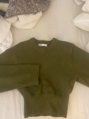 Olivgrön stickad tröja från Zara - Snygg olivgrön stickad tröja från Zara, den är bred i ärmarna men sitter åt i midjan. Använd en gång, så den är som ny, pris kan diskuteras💞💞storlek M men sitter som S
