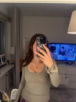 Gina tricot - Snygg beige - grön tight långärmad tröja från Gina. Den är i storlek xs och använd få gånger. Sitter tight o fint på kroppen med slitsar på varsin arm💕