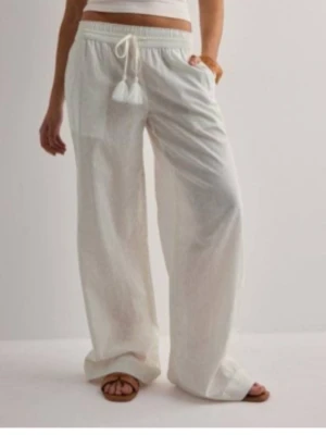 Vita vida linnebyxor med dragsko - Jätte fina linne byxor från Nelly.  Fint skick väldigt fåtal gånger använda. Lite slitningar längs ner på benen då dom är lite långa på mig men annars jätte fint skick! Vita storlek x-small