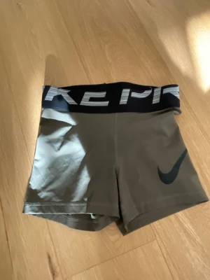 Nike Pro gröna träningstights shorts - Snygga gröna Nike Pro shorts med svart bred resår i midjan där det står 'NIKE PRO' i vitt. Tight passform och korta ben. Lappen är bortklippt men skulle säga att de är xxs/xs