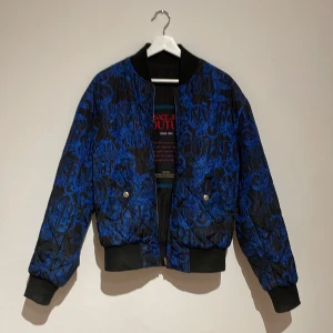 VERSACE JEANS COUTURE Reversible bomberjacka - Jackan är reversible, köpt för fullpris (5000kr) på johnells. Jackan har inga skador eller liknande. Ser helt sprillans ny ut. Storleken är XS men den sitter som en S