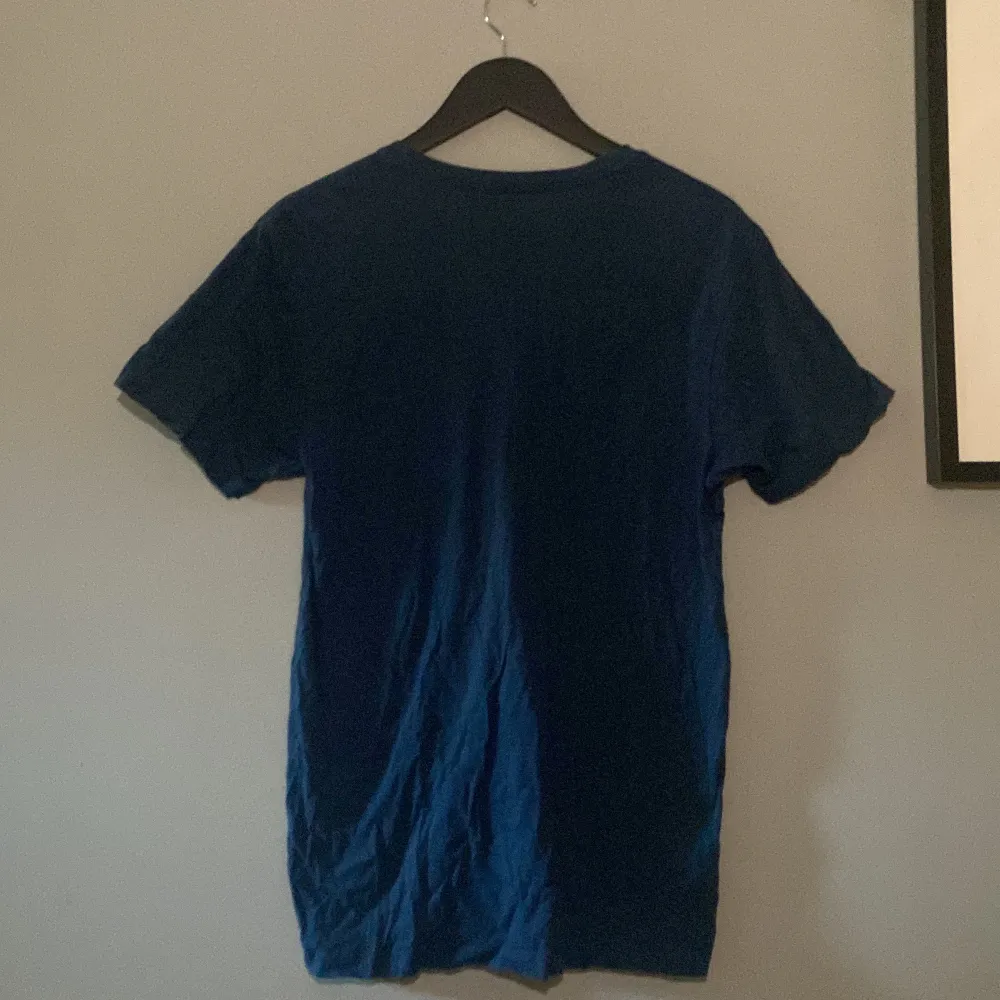 Marinblå Patagonia t-shirt med cirkulärt tryck på bröstet Modell: Slim fit  Nypris: 400kr. T-shirts.