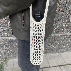 Handgjord virkad väska - Handgjord virkad väska som rymmer en vinflaska eller annan flaska i liknande storlek. Finns i flera färger. 100% recycled cotton. 