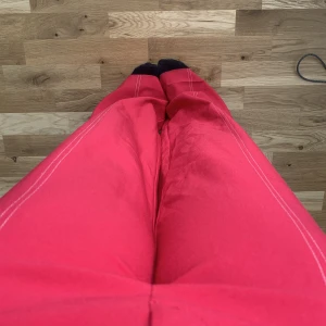 Rosa Kostymbyxor - Perfekta Barbie byxan! Rosa högmidjade kostymbrallor från NAKD i strlk 36. En vit söm på vardera ben. 