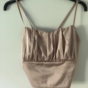 Topp  - Jättefin sommartopp i silke i ljus rosa den går att justera efter sin egen kropp, öppen i ryggen. fler bilder kan skickas vid intresse. Den är i strl S passar även XS. Den är fläckfri och nästan som ny använd ett fåtal gånger. Frakt ingår ej