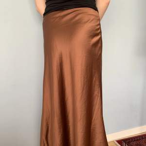 Lång kjol från NAKD, strlk 36. Funkar även som lågmidjad på en XS. Midjemåttet är 72 cm, längden 90 cm.