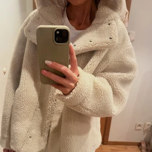 Teddy jacka med luva  - En vit/ lite créme färgad Teddy jacka med luva, perfekt nu till hösten🐻. Jag säljer denna då jag inte känner att jag har någon användning för den längre. Men jag själv tycker dock den är väldigt snygg💓. 