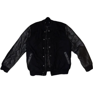 JACKA - Varsity jacka i svart med läderärmar. Ena fickan har ett hål i sig men det går att sy ihop om man vill! 