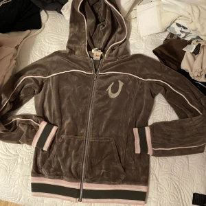 True Religion vintage velour zip up 🤎 - ⚜️Äkta och riktigt RARE True Religion kofta~ ⚜️Condition 8/10, köpt second hand och enbart provad. Mjuk och varm perfekt till hösten! ⚜️Storlek M. Grå/brun med rosa detaljer. ⚜️Kolla gärna in min profil för fler plagg och mycket y2k! ⚜️