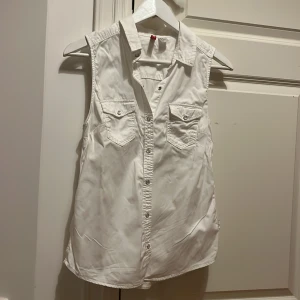 Vit skjorta kortärmad - Vit kortärmad skjorta från H&M divided. Oanvänd. Perfekt att ha under en stickad t.ex. Strl 38.