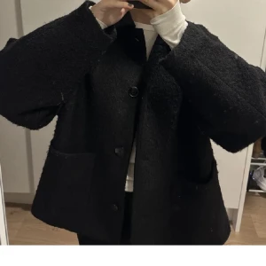 Svart kort kappa - Säljer min jättefina kappa från monki i storlek xxs, jag tycker den passar både xs samt s då den är lite lite oversized. Den är i perfekt skick då jag knappt har använt den. Dom 2 första är lånade bilder. 