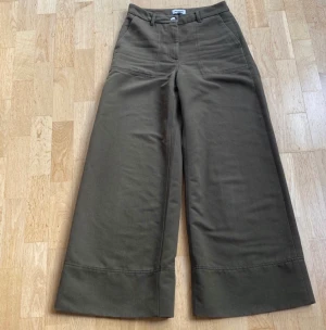Weekday, höstbyxor storlek 36 - Olivgröna byxor, storlek 36. Välanvända, noppriga med en del slitage. Naggade i nederkant . Tvättade, rena. 88% polyester, 7% viskos, 5% ull.