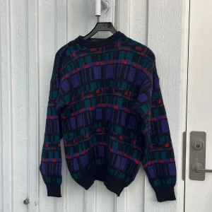 Multifärgad stickad tröja  - Multifärgad stickad tröja från märket Woolsey i storlek M. Tröjan är Oversized i modellen så den passar också L. Köpt second hand på Beyond Retro. Säljer då den inte kommer till användning