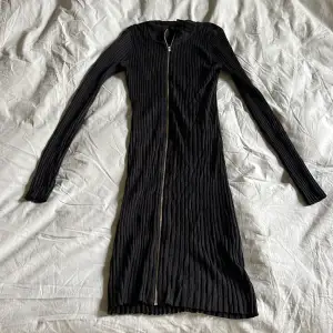 Stickad svart knälång klänning med blixtlås. Fint använt skick. Storlek Small