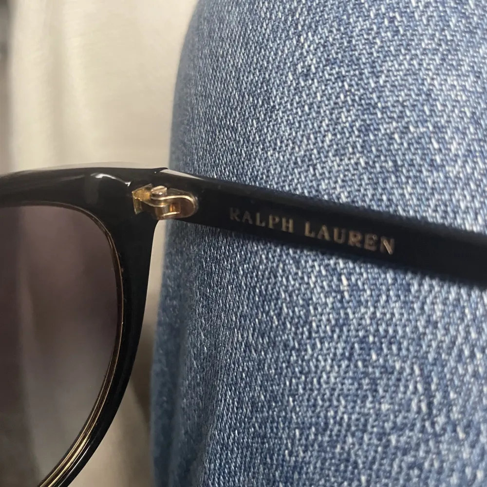 Äkta Ralph Lauren solglasögon, nästan aldrig använda och inga ripor💓 svarta med guldiga detaljer och mörklila till svarta rutor! Säljer endast för att jag köpt nya i annan färg!💓nypris: ca 1100kr! Pris kan diskuteras💓. Övrigt.