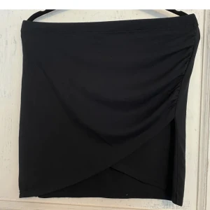 Tajt svart kjol med slits - Tajt svart kjol med slits från bikbok. Aldrig använd.