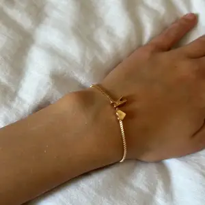 Guldigt armband med initialen K. Lite använd och är lite bronz aktig på k cg hjärtat