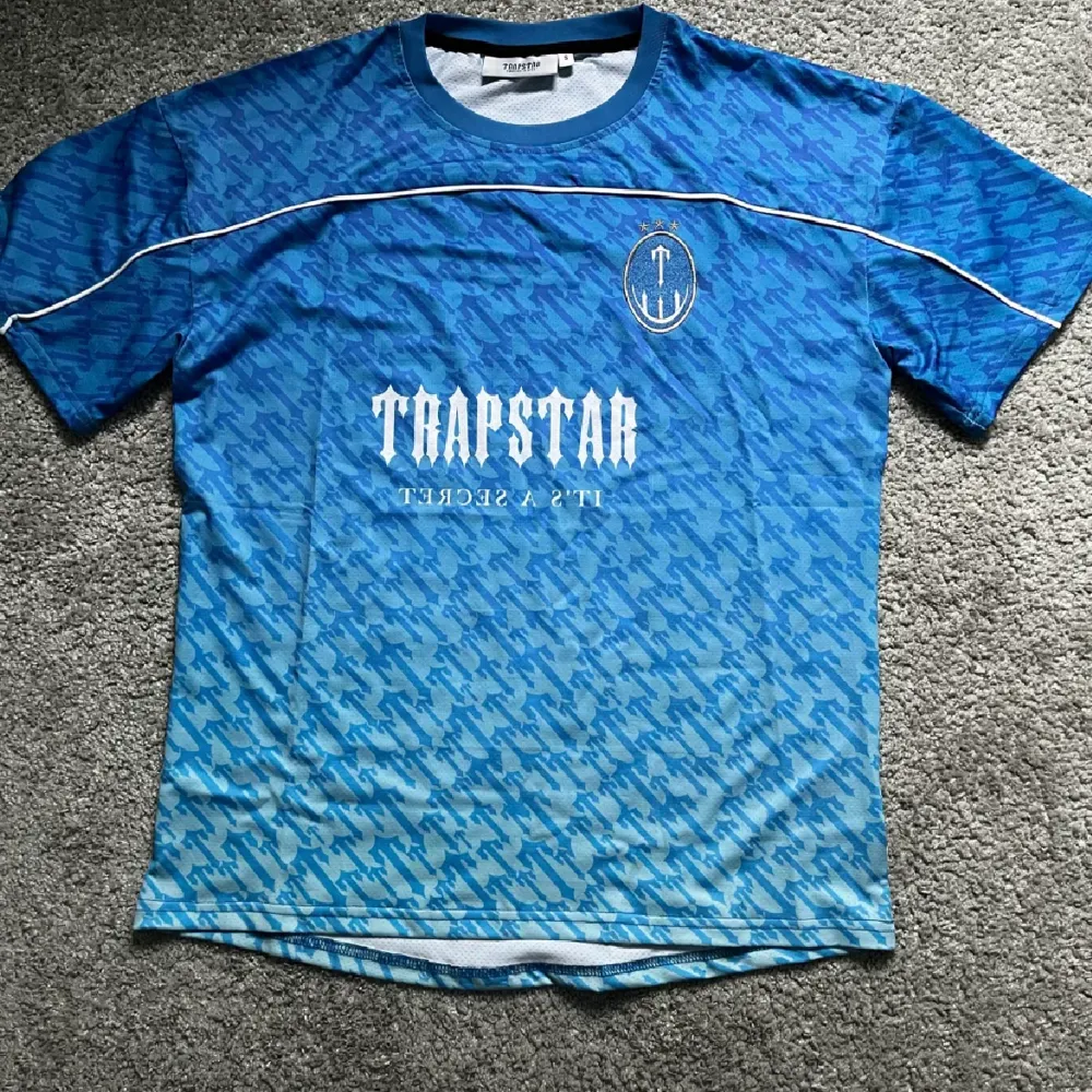 Hej! Säljer nu min oanvända trapstar jersey. Den är storlek S men passar som M och är lite oversized. Den är en replika. Den är rikigt fin. Pris kan diskuteras vid snabb affär💨. T-shirts.