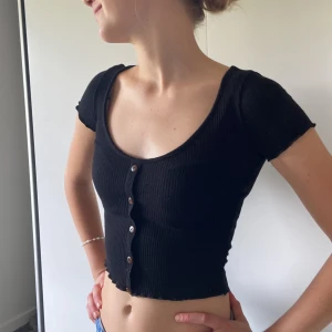 Svart topp - Svart topp från Even&Odd i storlek XS. Ribbat material med knappar fram. Använd några gånger men fortfarande bra skick!