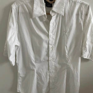 Vit kortärmad Ralph Lauren skjorta - Vit Ralph Lauren skjorta med korta/trekvart ärmar. Figursydd runt midjan🤍