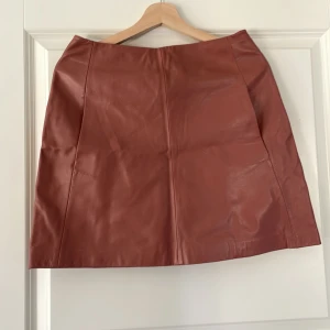 Skinnkjol Day, stl 34 - Beige (rust) skinnkjol med fickor framtill. Stl 34 men passar stl 36. Mycket fint skick från Day. 
