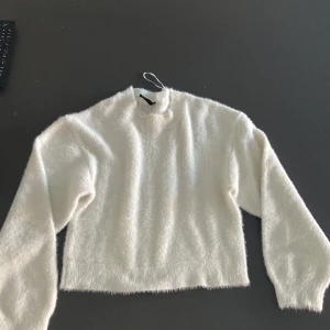 En vit lurvig tröja  - En vit lurvig mysig tröja. Den är använd några gånger men ändå i bra skick. Den är mjuk och varm. Den kan vara lite kort i midjan men annars perfekt .
