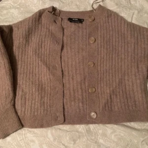 Beige stickad kofta - En beige stickad kofta från Bikbok. Den är i fint skick och endast använd ett fåtal gånger. Jag säljer pågrund av att den inte kommer till användning. (Priset kan diskuteras)