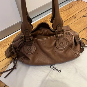 Chloé Paddington  - Jättefin väska i brun färg från Chloé i modellen Paddington. Köpt från Vestiaire. Dustbag följer med! Djup 15cm Längd 34