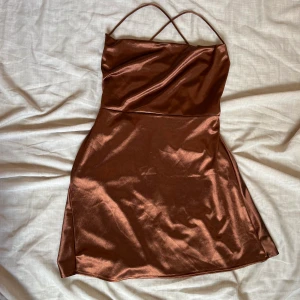 Klänning - Brun kort klänning.  Jag är 178 cm och den är lagom kort på mig. Använd en gång.