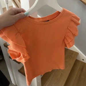 Orange topp Zara - Somrig gullig orange topp med volanger i ärmarna från Zara. Säljer då den inte kommer till användning, använd kanske 2 gånger. Bra skick och i storlek S!🧡