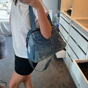 Jättesnygg jeans väska! - Säljer en jeansväska som man nog inte kan köpa i Sverige! Den rymmer mycket ock har flera fickor! Men kan ha på sig den på två olika sätt! Aldrig använd