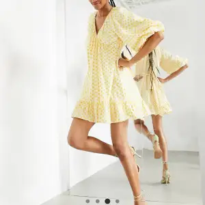Vacker klänning från ASOS edition. Elfenbetsvit omlottklänning med gula broderade blommor. Bara använd en gång. Inköpspris 1145. 