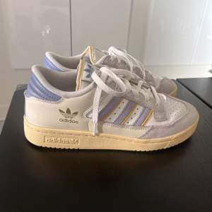 Adidas Centennial 85 low i nyskick! Använda kanske en eller två gånger och har inga defekter. De är i storlek 40, men är för små för mig som är storlek 39. Skulle tro att de passar för någon i storlek 38 (kvinnostorlek). Jättefin lila och ljusgul färg. 😚