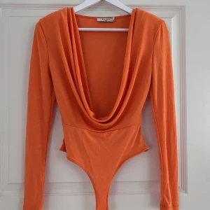 Festlig body - Fin och utstickande body från Nakd med axelvaddar. Väldigt sparsamt använd och därav i väldigt fint skick! 