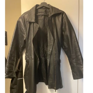 Skinn trenchcoat/jacka - Säljer denna denna jackan eftersom de inte är min stil längre. Köpte den secondhand så den är nopprig inne i jackan som kan ses i bild 3. Står ingen strl men skulle gissa på att den är 40-42, kan passa 38 om man gillar oversized. Köparen står för frakten💕