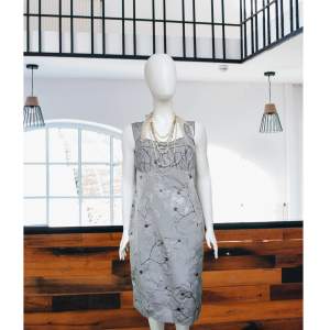 Elegant aftonklänning skräddarsydd av silvertråd prydd med sagoliknande magnolia blommönster med grenar. Det unik kläd för kvinnor att vill representera sig med sina outit som ovanliga, sofistika. Klänningens märke är väl igenkännligt i Centraleuropa.