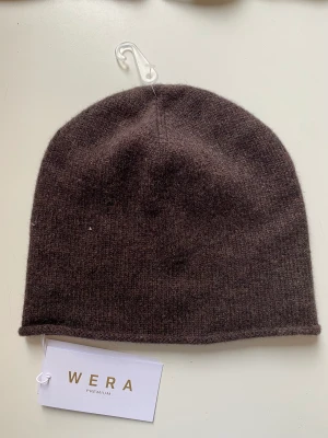 Brun mössa - Oanvänd brun mössa från Wera, lappen kvar. 95% ull, 5% kashmir🤎samma som på andra bilden fast brun