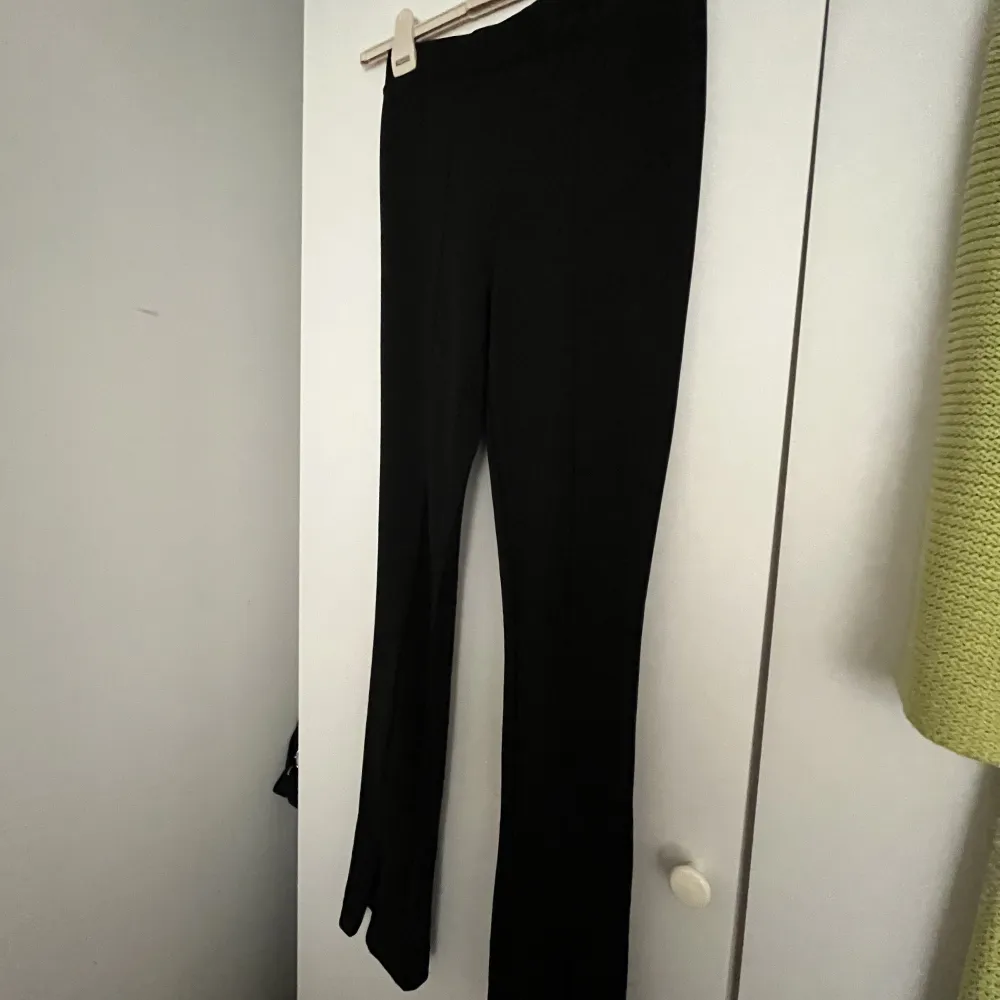Säljer ett par svarta kostymbyxor som är använda väldigt fåtal gånger. Dem har slit där nere som man kan justera själv!. Jeans & Byxor.