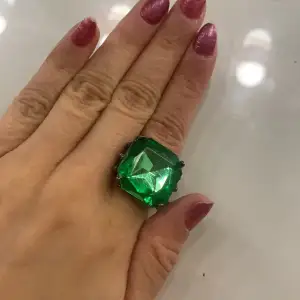 En svart/grå ring med en grön diamant på. aldrig använt men den är i bra skick och bekväm att ha på sig, kommer inte ihåg vart jag köpte den. Storleken är i sista bilden, den kan vara antingen lite större eller mindre för det var svårt att mäta storleken.