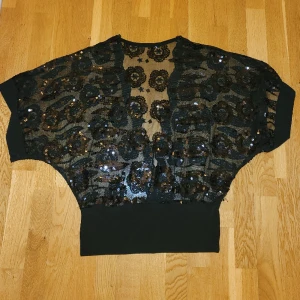 Topp - Superfin festtopp med paljetter och delvist öppen rygg. Sitter superfint på, perfekt nu till nyår. Står ej storlek men passar mig som har M. Skriv privat för fler bilder. Kan fraktas men köparen står för frakten 💕