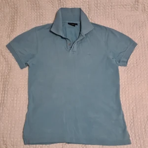 Pikétröja Stl M East West i turkos färg - East west pikétröja i storlek Medium säljes då den blivit för liten för mig.  Den är fläckfri, rökfri samt kommer ifrån djurfritt hem. Den är använd men fräsch.  Mvh Brand Guy.