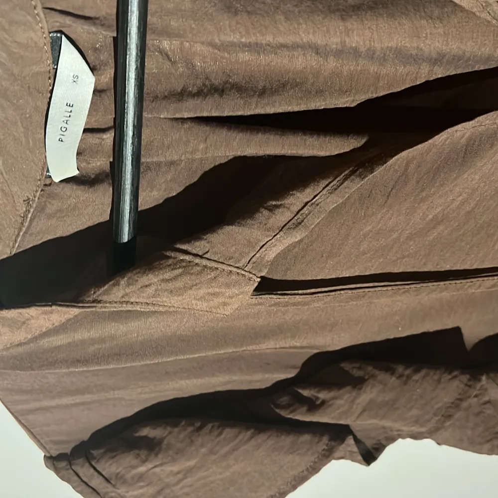 Detta är en super fin, brun blus med vackert fall och superfint material. Denna blusen har tyvärr inte kommit till användning men är därför i ny  skick. Den har storlek XS och går ej att få tag i här i Sverige. . Blusar.