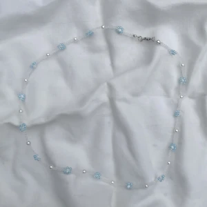 Pärlhalsband med blommor - Handgjort pärlhalsband med blå,vita och genomskinliga seedbeads samt akrylpärlor. Kan både förkortas och förlängas vid behov. Skriv om du har frågor💗Klicka på min profil för fler smycken i samma stil☺️