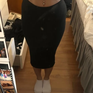 Svart kjol - En längre kjol som knapptanvänts storlek xs