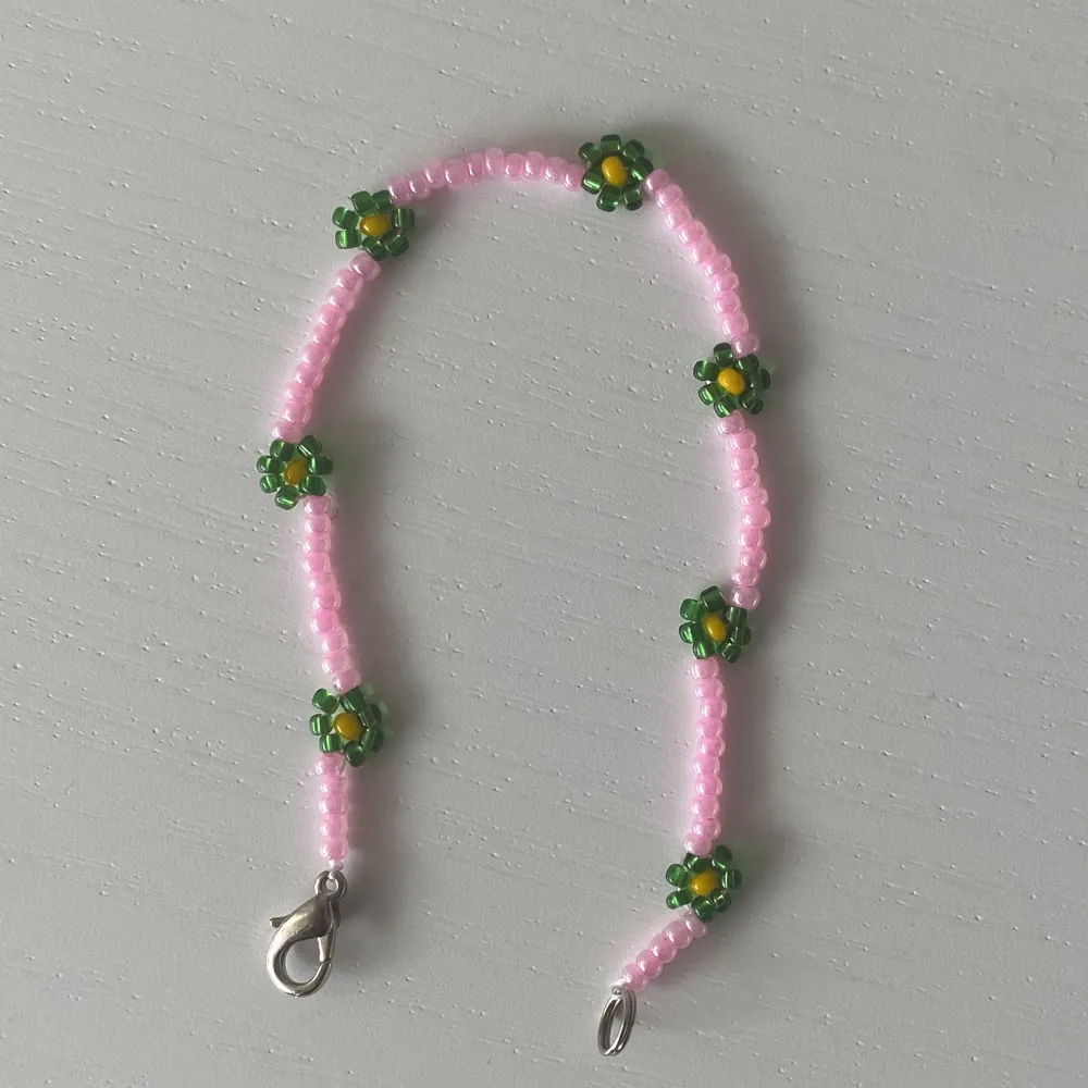 Supergulligt handgjort armband av pärlor med blommor på. Accessoarer.