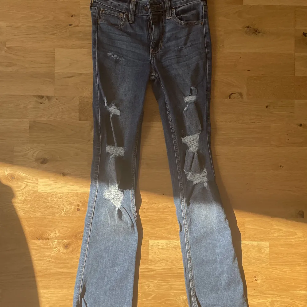 Blå hollister bootcut jeans, W23, L30. Är rätt små, skulle gissa att de är för en 10-12 åring.. Jeans & Byxor.