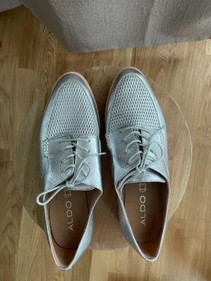 Silvriga retro-skor - Helt oanvända silvriga skor, riktigt snygga till allt men särskilt om man stylar dem med en kostym, skjorts eller byxor. Stilrena med en ”retro” touch. 