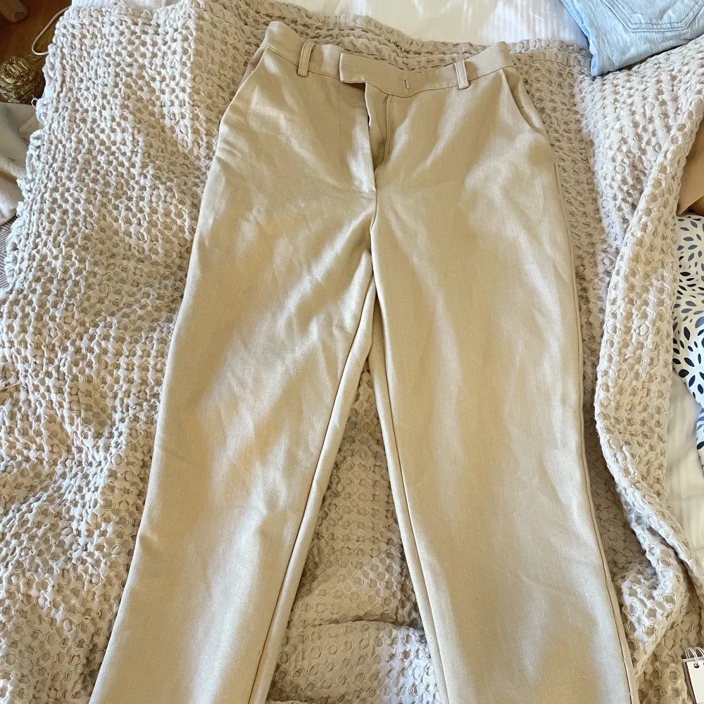 Beigea kostymbyxor från NAKD strl 32, lite stora i storleken så passar mig som har 34 . Jeans & Byxor.